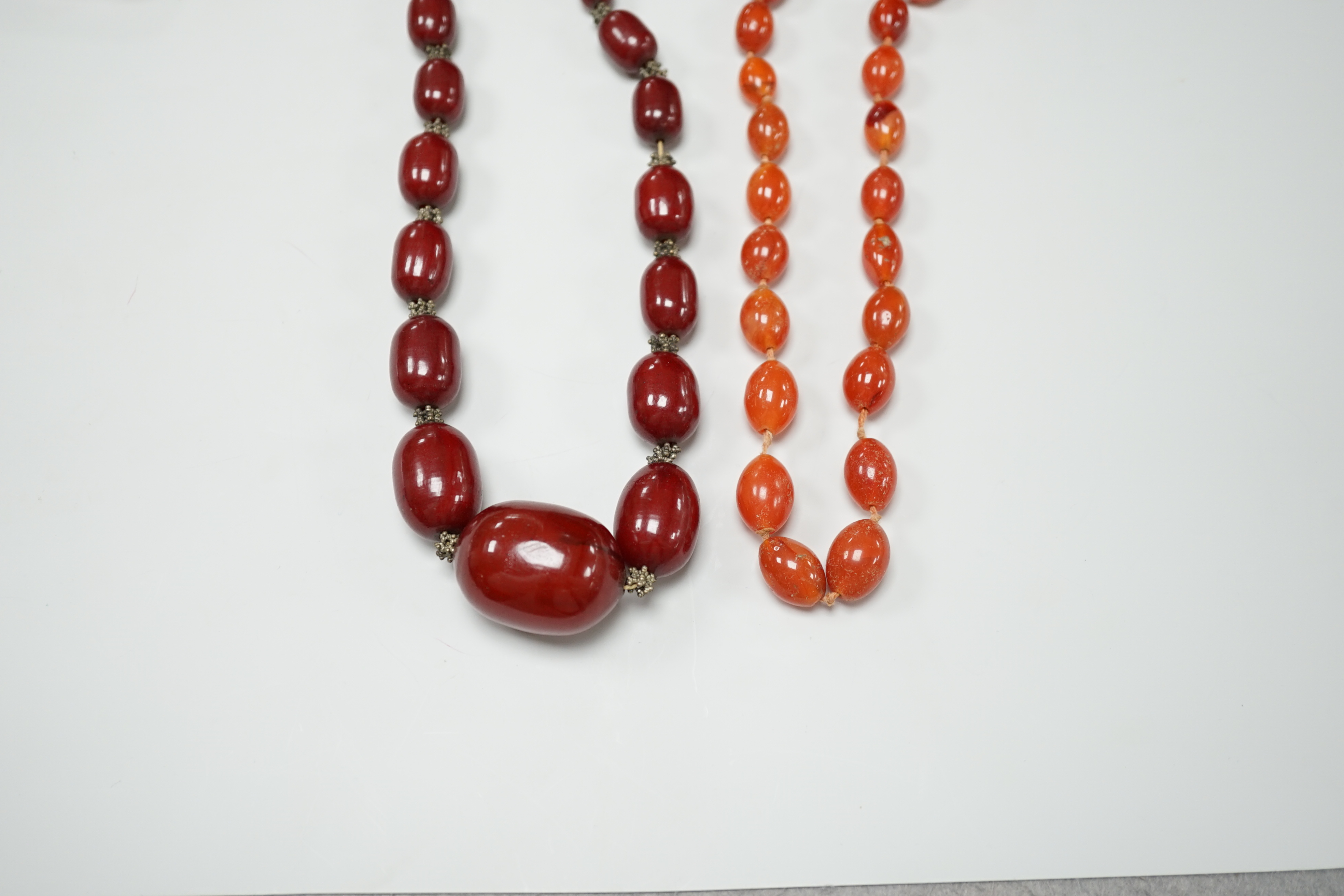 A simulated graduated red amber bead necklace, 52cm and an orange agate bead necklace, 92cm